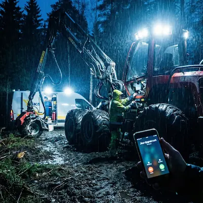 Mobil hydraulikservice utför akut reparation av en skogsmaskin i regn och mörker med texten Jour dygnet runt.